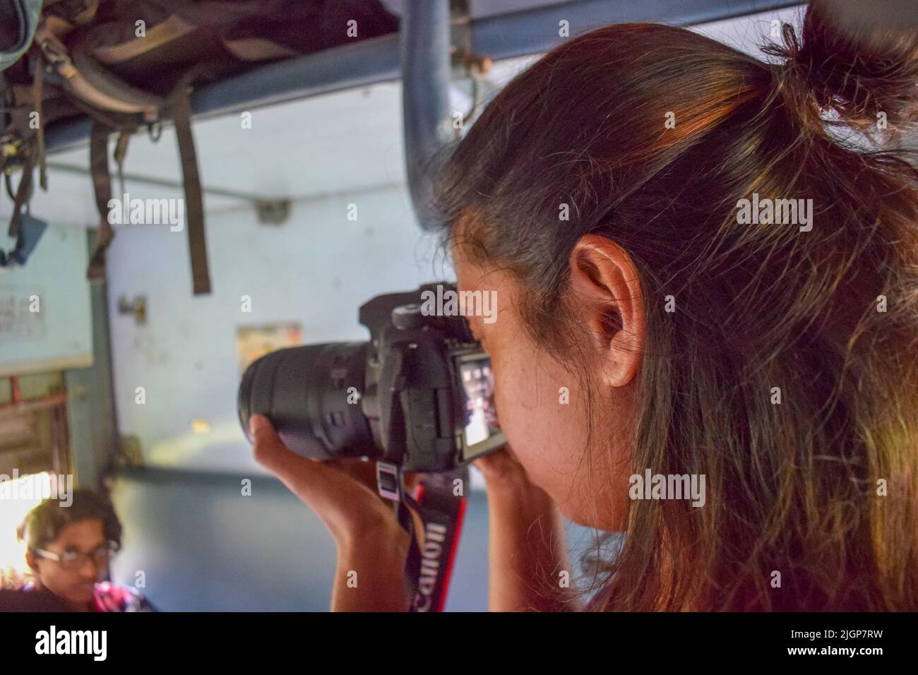 An Indian women taking photos during traveling in a train. women tourist and traveling photography concept Stock Photo