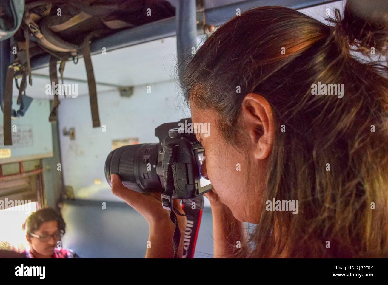 An Indian women taking photos during traveling in a train. women tourist and traveling photography concept Stock Photo
