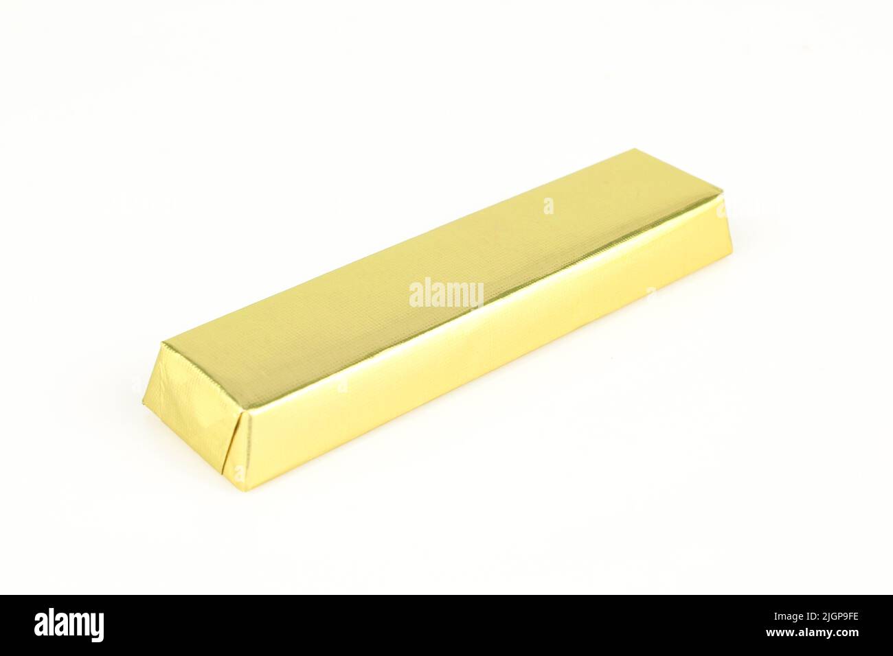 Milk chocolate bar resting in gold foil wrapper. Isolated Stock