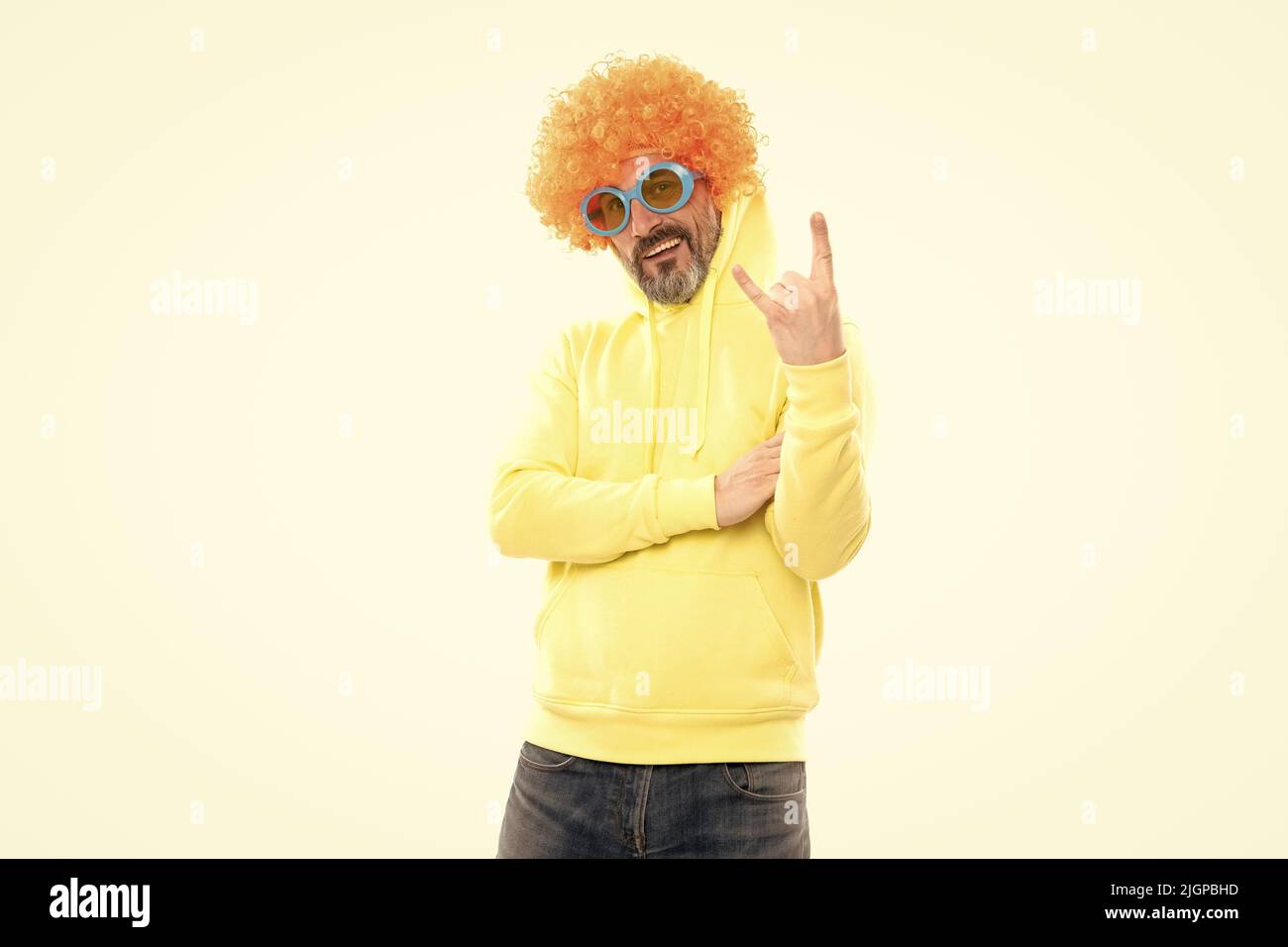Funny man wear orange wig with party look showing horns sign gesture
