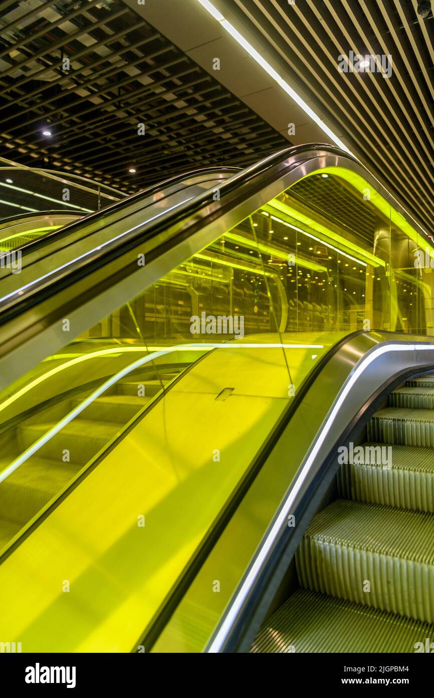 Platform level of Canary Wharf station on the new Elizabeth Line underground in London. Escalators are encased in yellow glass. Stock Photo