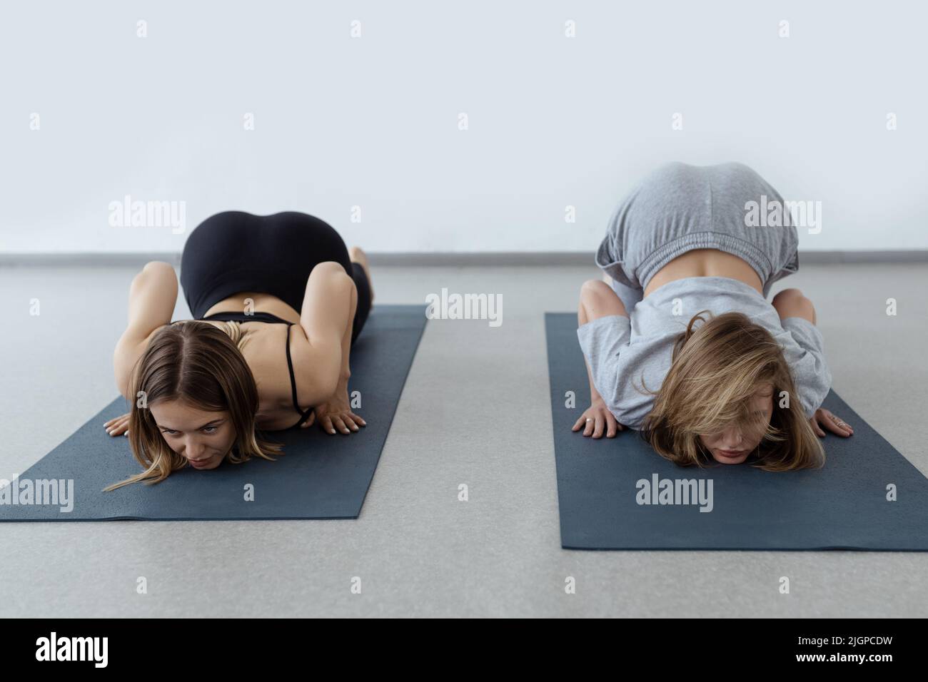 young flexible girl doing yoga and gymnastics indoor gymnastics, flexibility and stretching assana lying backbend Stock Photo