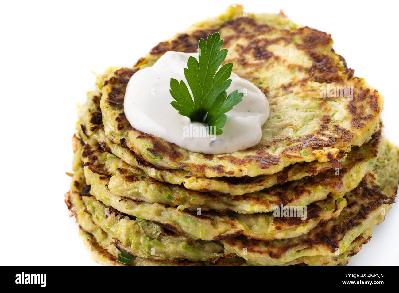 Zucchini fritters with yogurt sauce isolated on white background Stock Photo