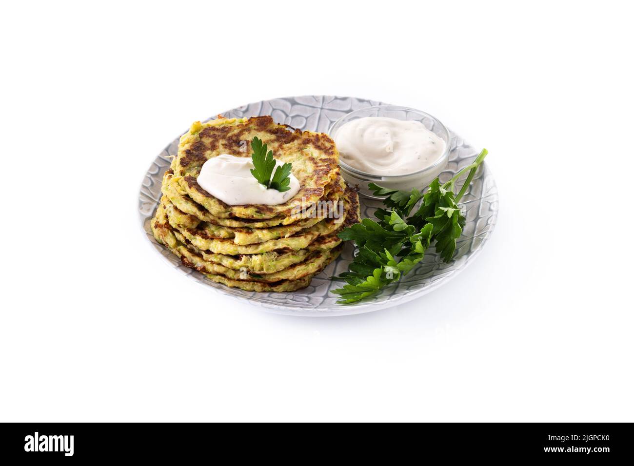 Zucchini fritters with yogurt sauce isolated on white background Stock Photo