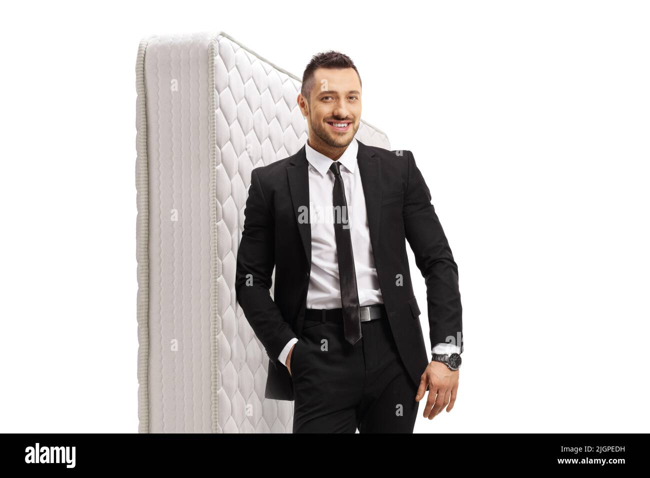Salesman leaning on a white bed mattress isolated on white background
