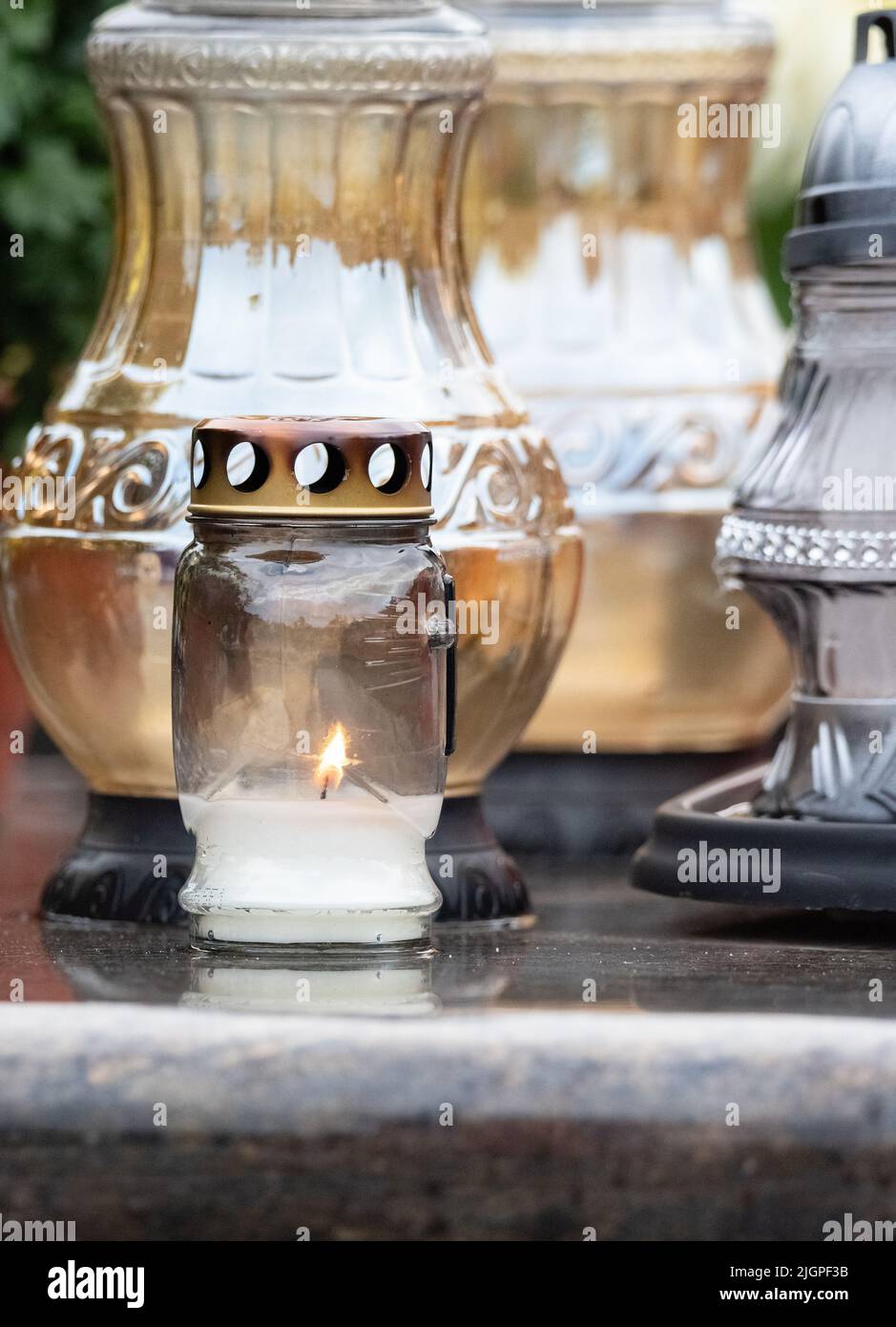 All Saints' Day and burning candles next to flowers on the graves