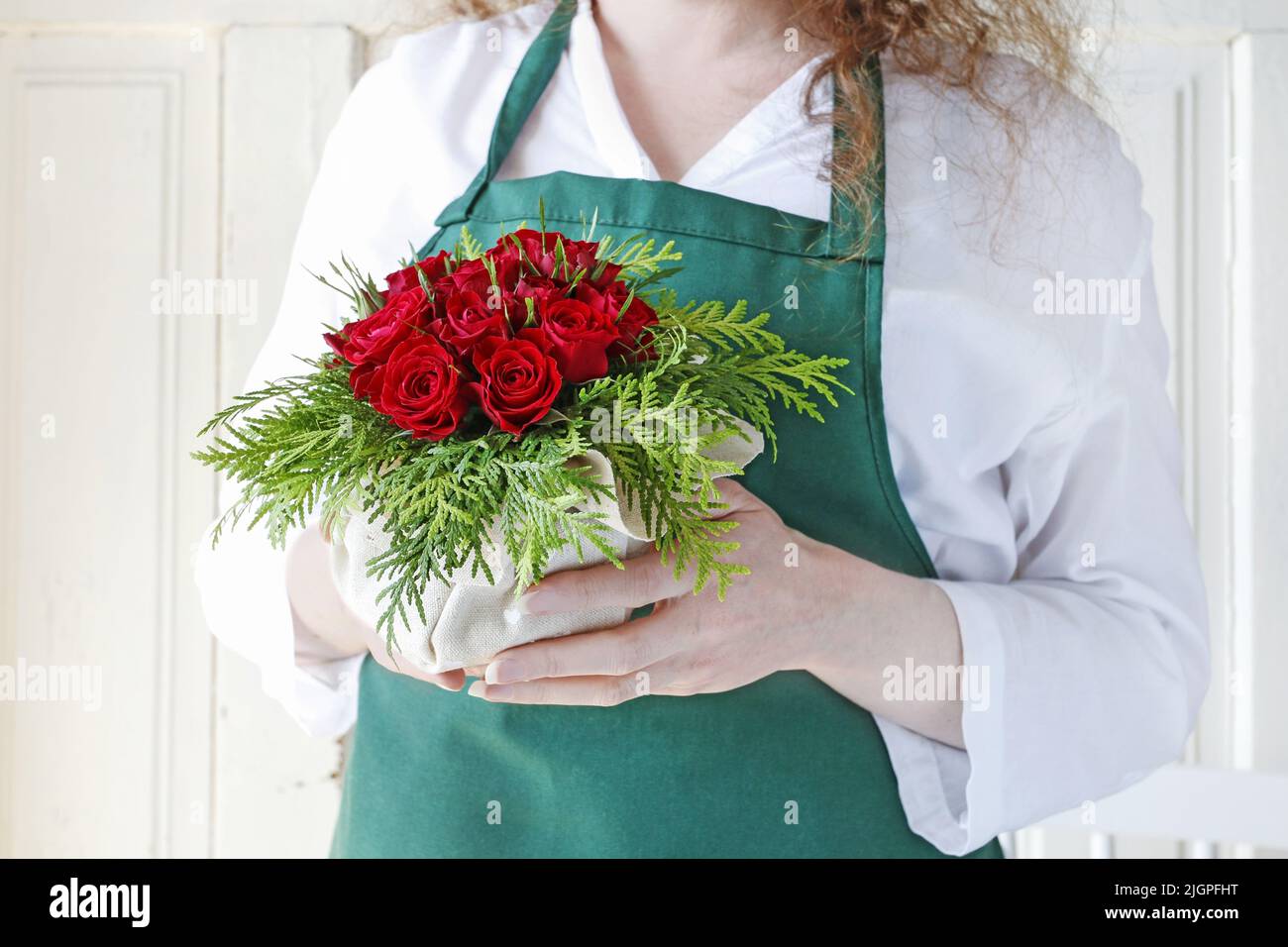 Florist at work: Woman shows how to make a floral arrangement with red ...