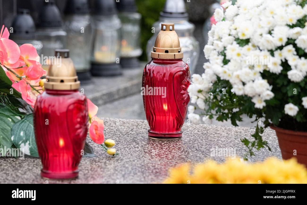 All Saints' Day and burning candles next to flowers on the graves