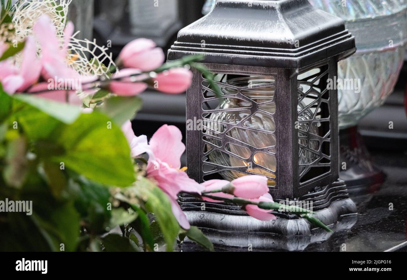 All Saints' Day and burning candles next to flowers on the graves