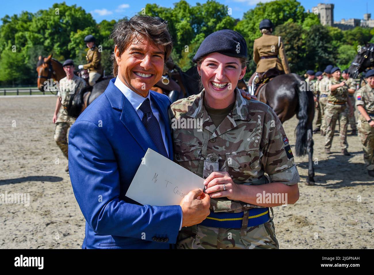 Windsor Castle, Windsor, Berkshire, UK. 8th July 2022. EMBARGOED UNTIL 12th JULY  Tom Cruise being given a wedding invitation by Jess Young during his visit to meet members of the King's Troop Royal Horse Artillery, which Tom introduced back in May, during the Platinum Jubilee Celebration, on a private visit in the Private Grounds of Windsor Castle   Credit:Peter Nixon/Alamy Live News Stock Photo