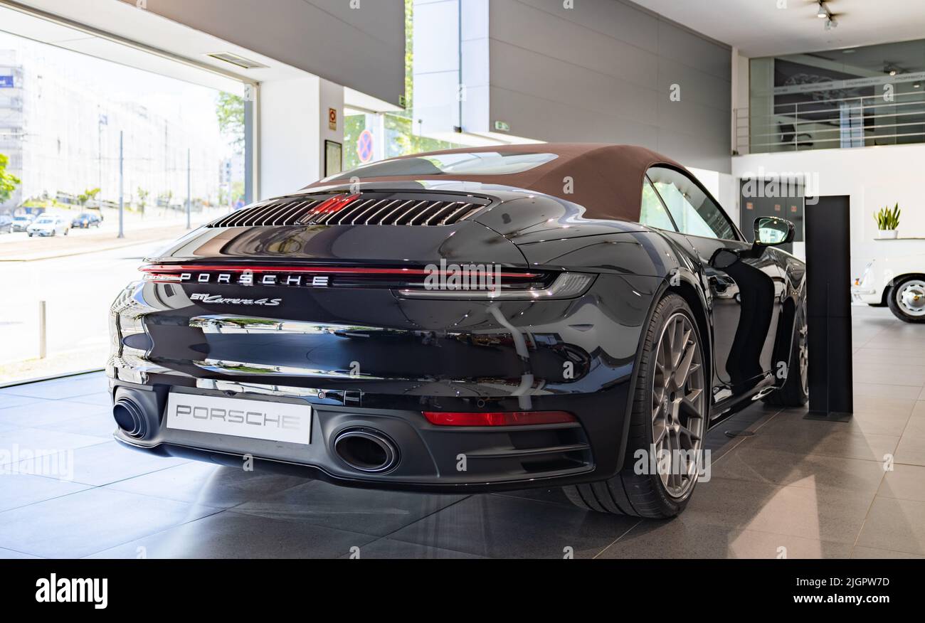A picture of a black Porsche 911 Carrera 4S Cabriolet inside a dealership. Stock Photo