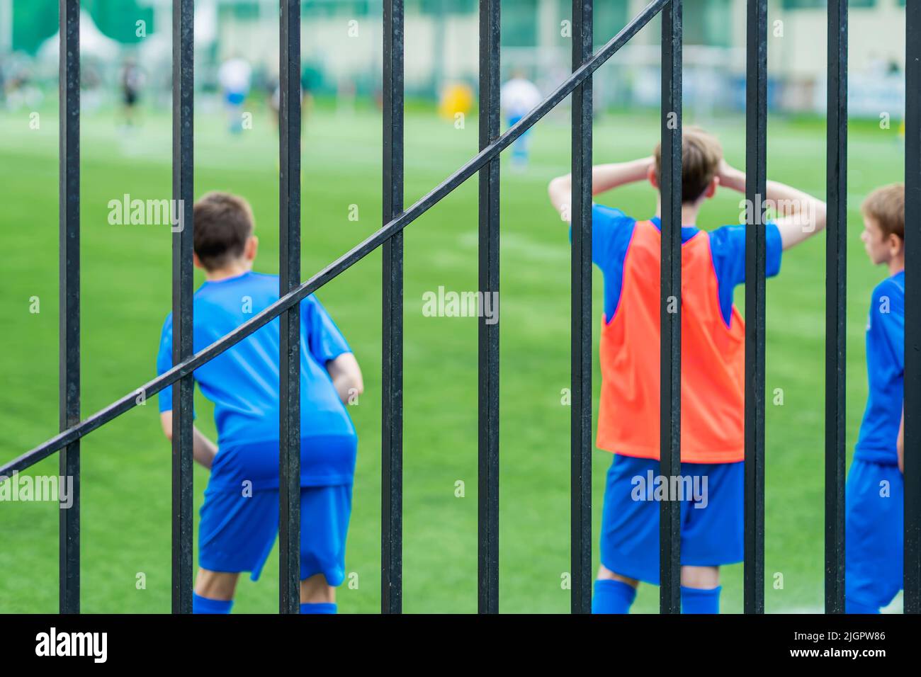 Reserve Soccer Players by football field behind hedge. Teenagers Boys