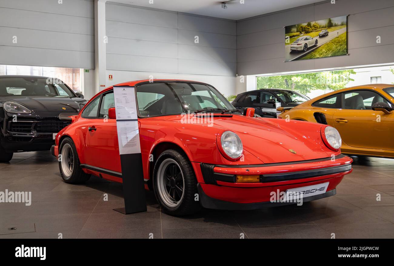 A picture of a red Porsche 911 Carrera 3.0 inside a dealership. Stock Photo