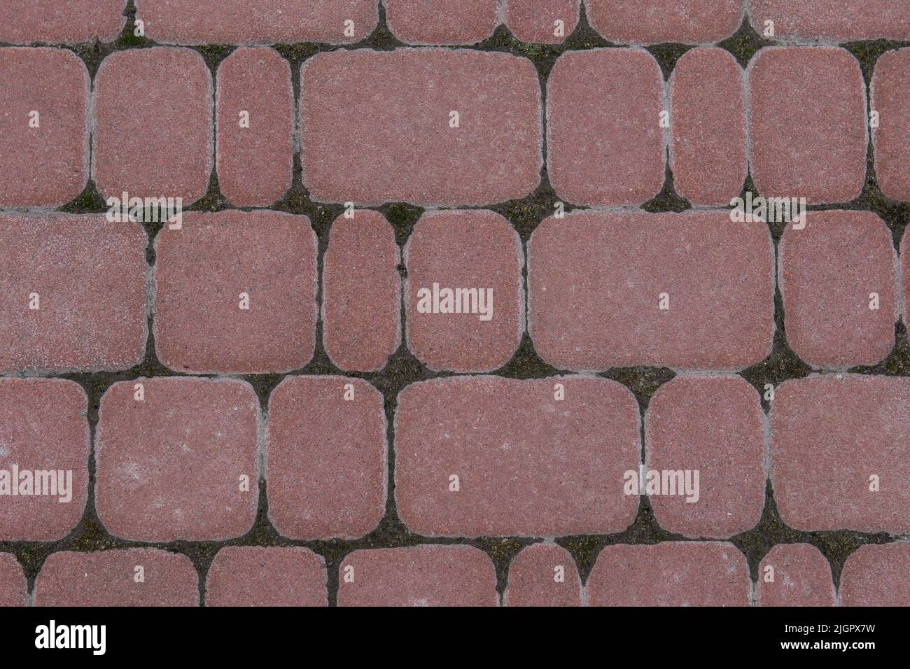 Road tiles of different sizes. Top view. The uneven pink color of the tile makes it look like a natural stone. Footpath. Urabism Stock Photo