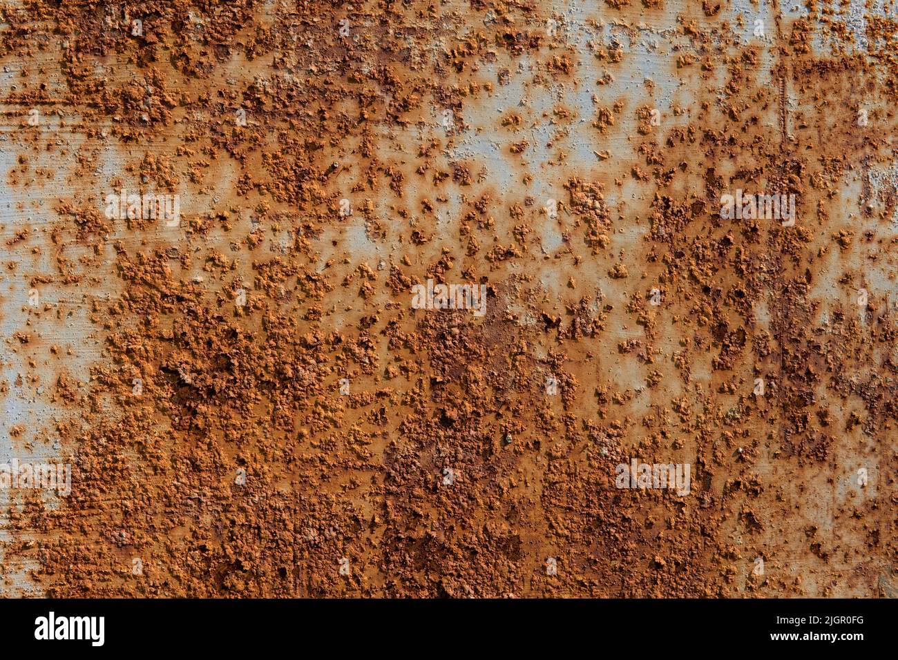 The rusty metal fence is covered with pimples. The aging process of iron. Metal oxidizes and corrodes. Process of degradation and decomposition. Rusty background. Rust texture Stock Photo