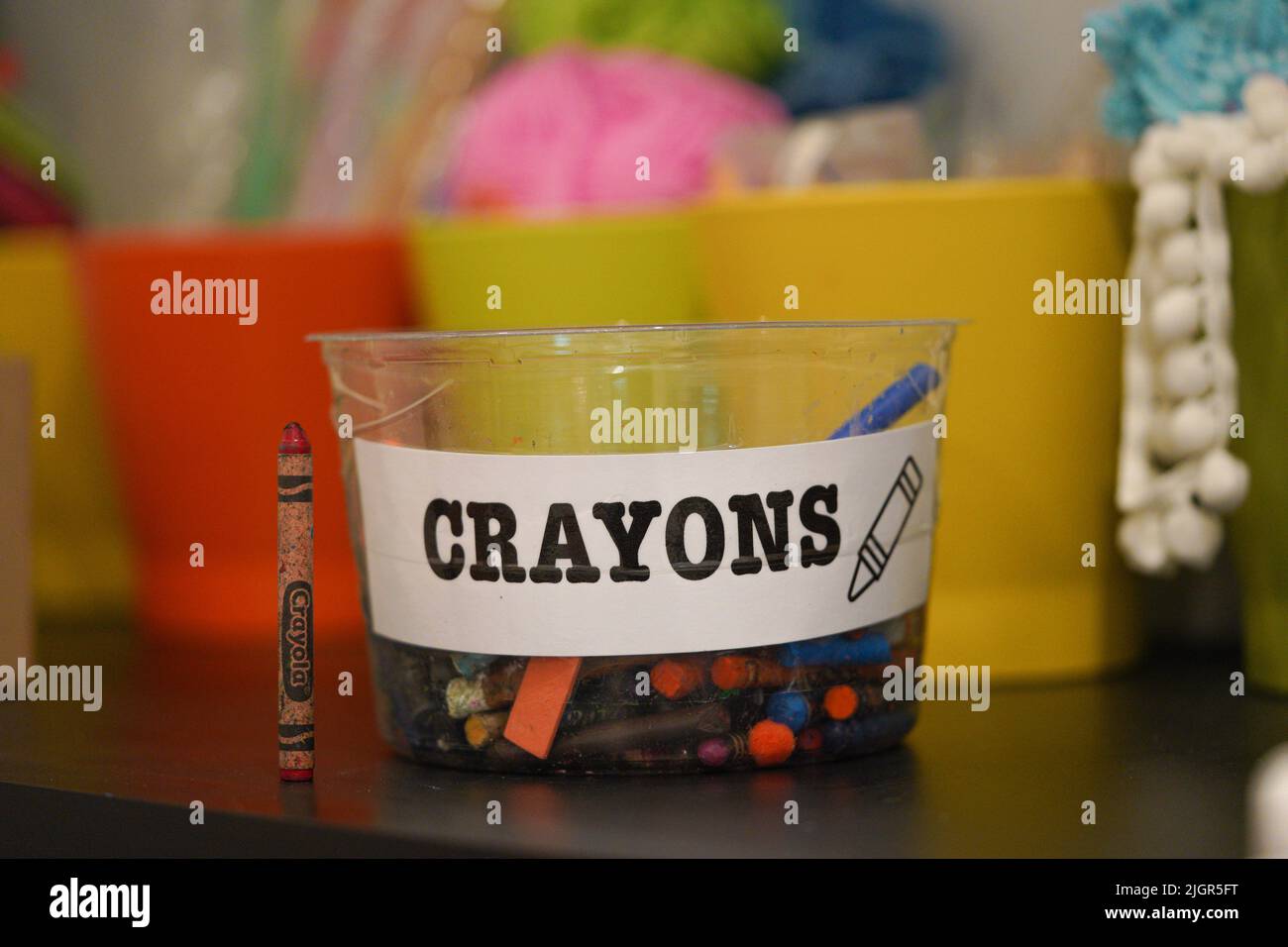 Crayons wax colors on a plastic box with crayons label at kids