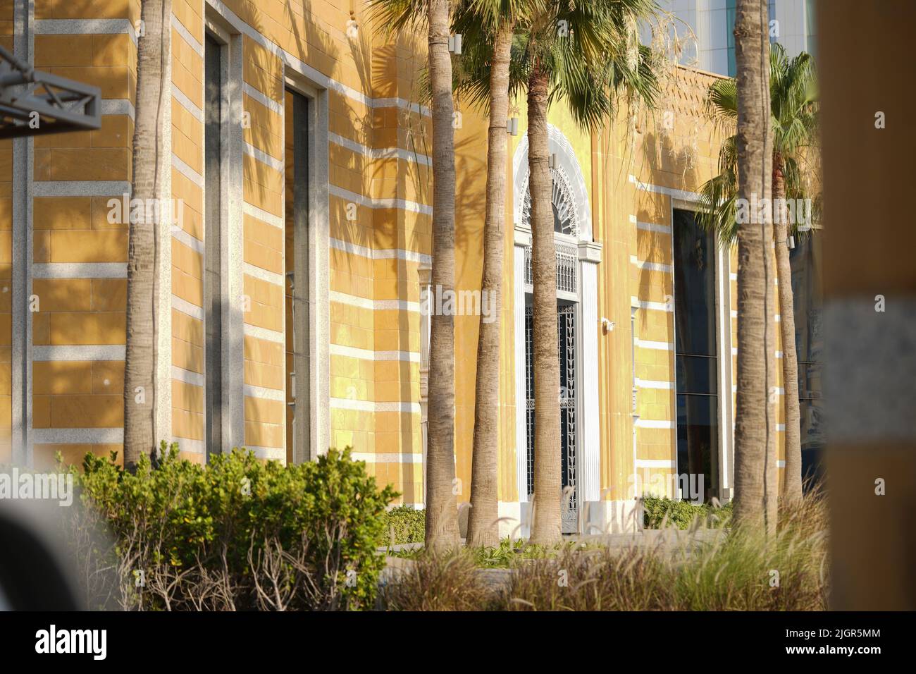 Yellow beautiful Building with many palm trees. Stock Photo