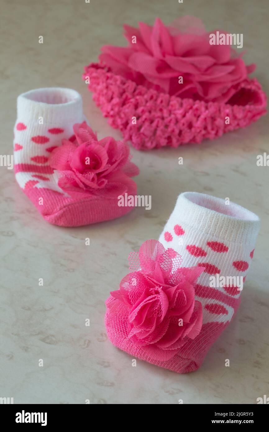 White socks in pink polka dots and a flower for the baby on the table Stock Photo
