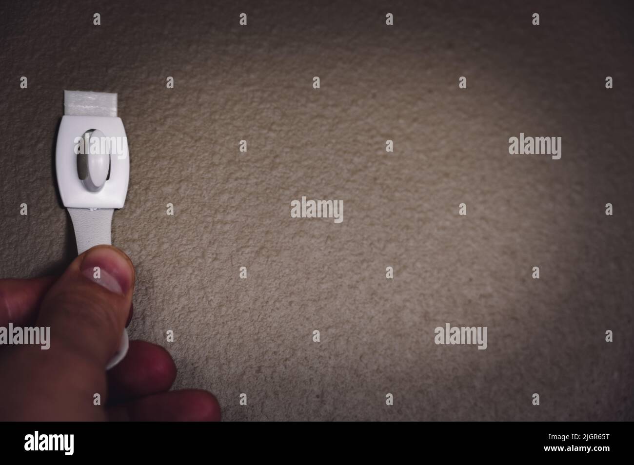 Selective focus on adhesive strip wall hanger that can be removed by