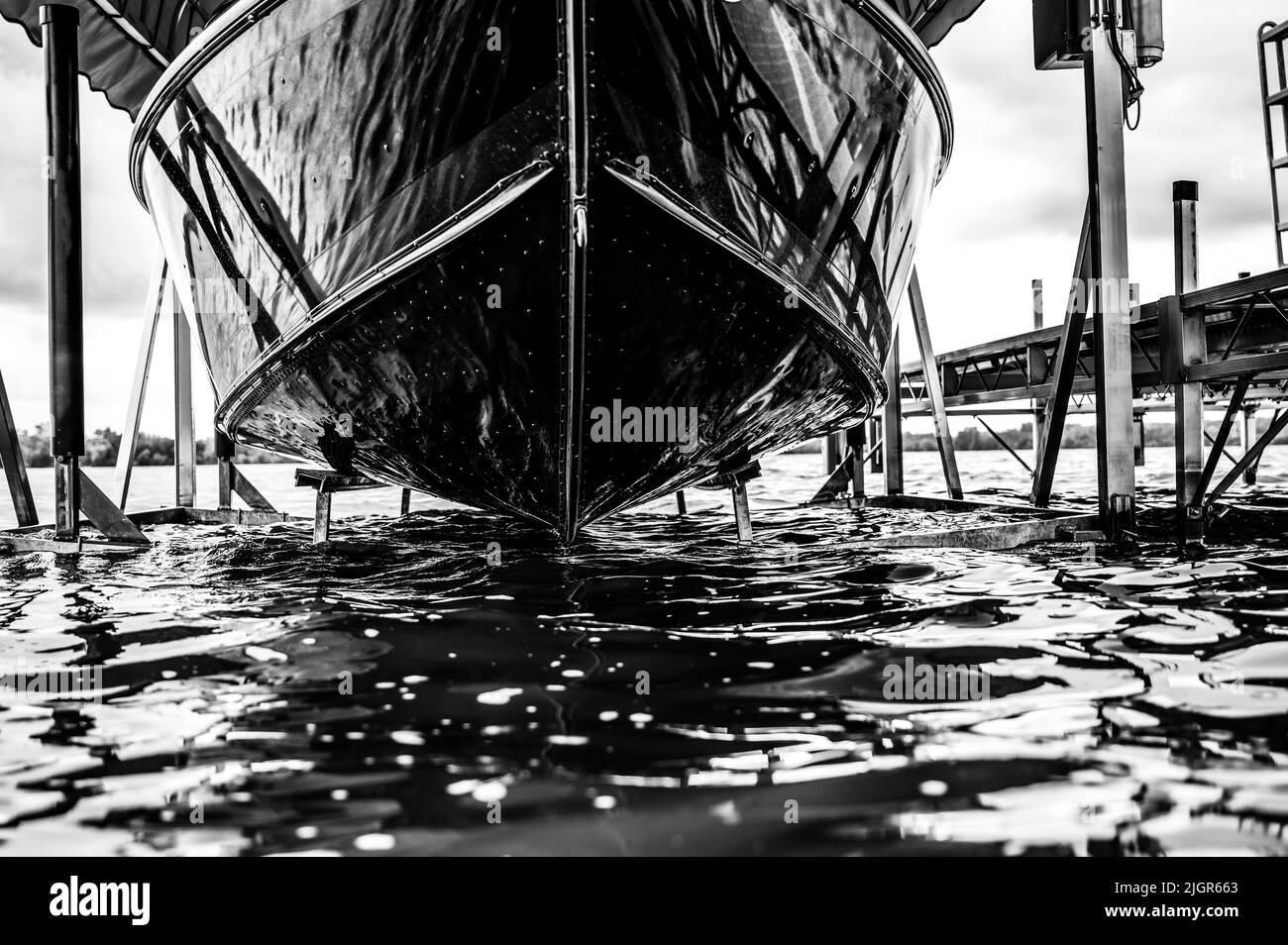 Boat with a hydraulic dock lift sitting above the water line on a lake