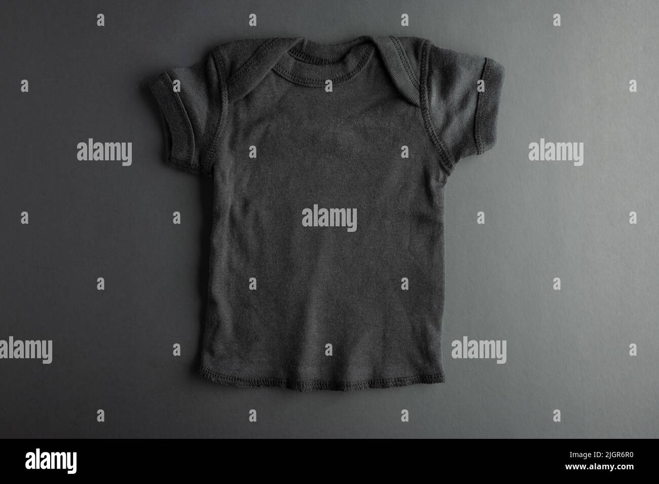 Flat mockup of a black children's t-shirt on a gray background - for boys. Layout for the design and placement of prints, logos, advertising. There ar Stock Photo