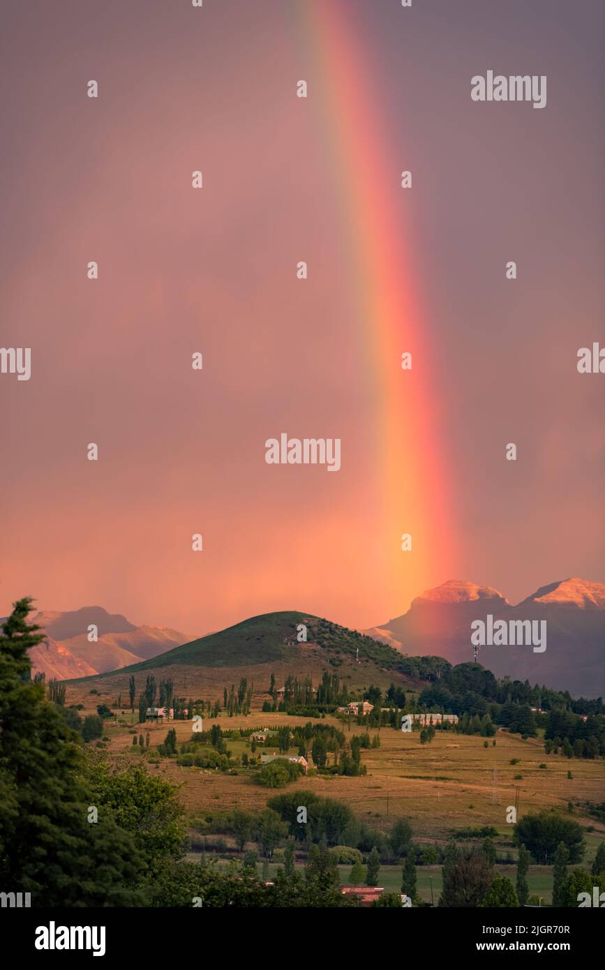 A rainbow in a sunset sky over a hill in Clarens, South Africa Stock Photo