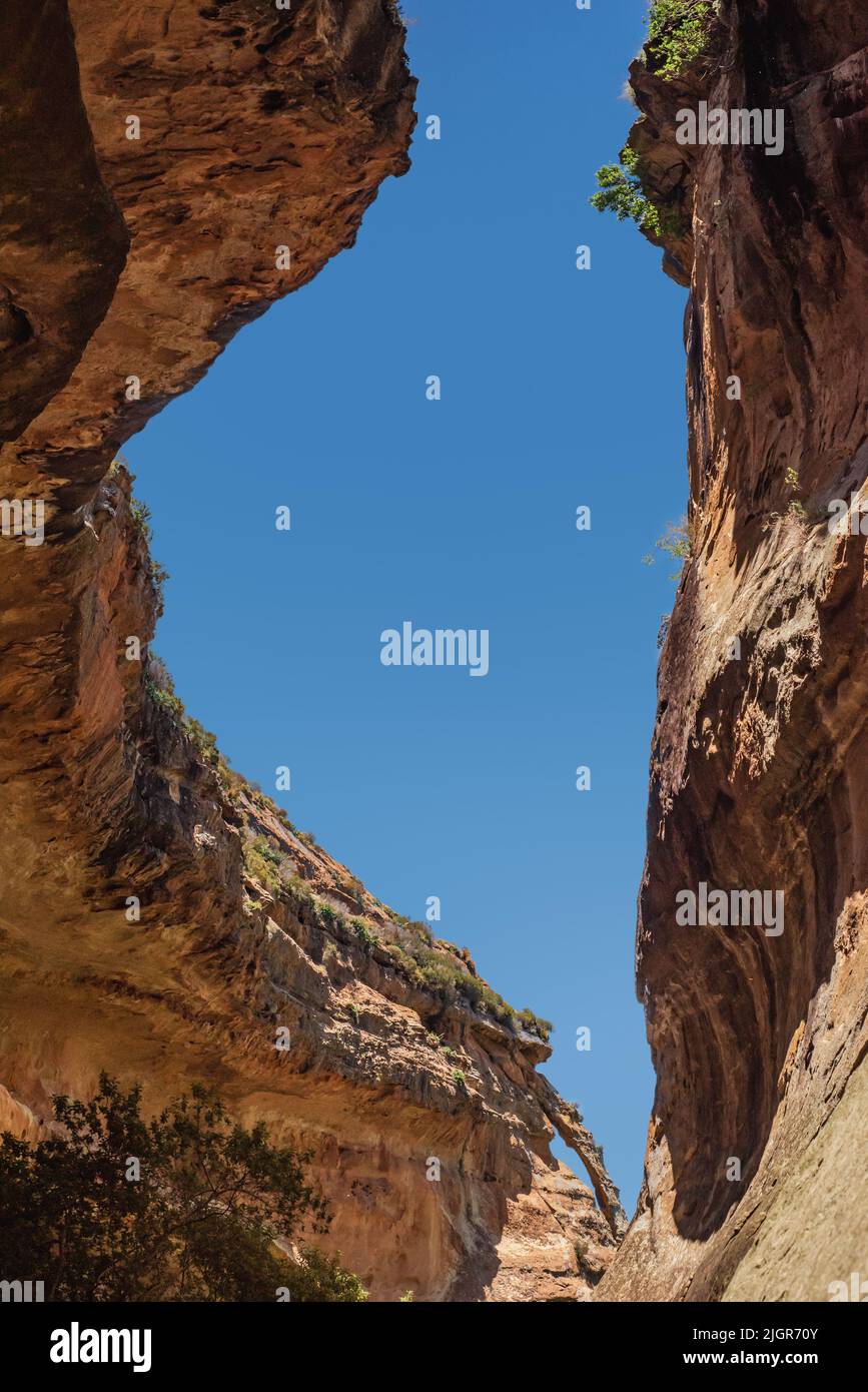 Looking up at a window of blue sky between overhanging cliff walls on the Echo Ravine Hike in Golden Gate Highlands National Park near Clarens, South Stock Photo