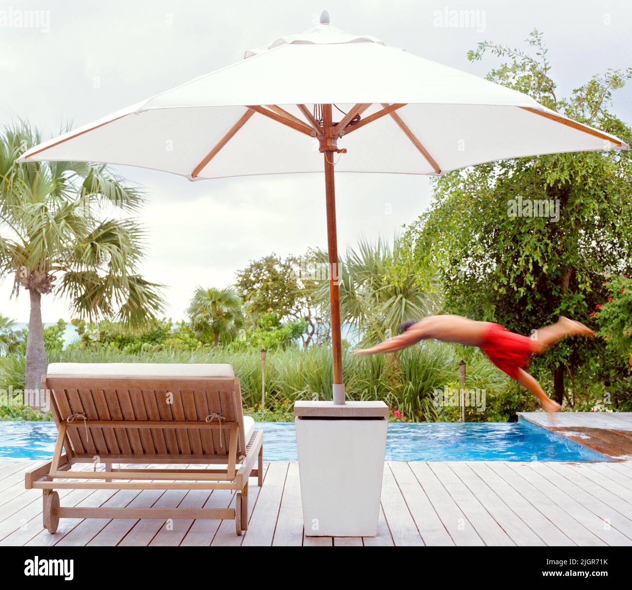Man diving into pool , Parrot Cay, Turks and Caicos Stock Photo