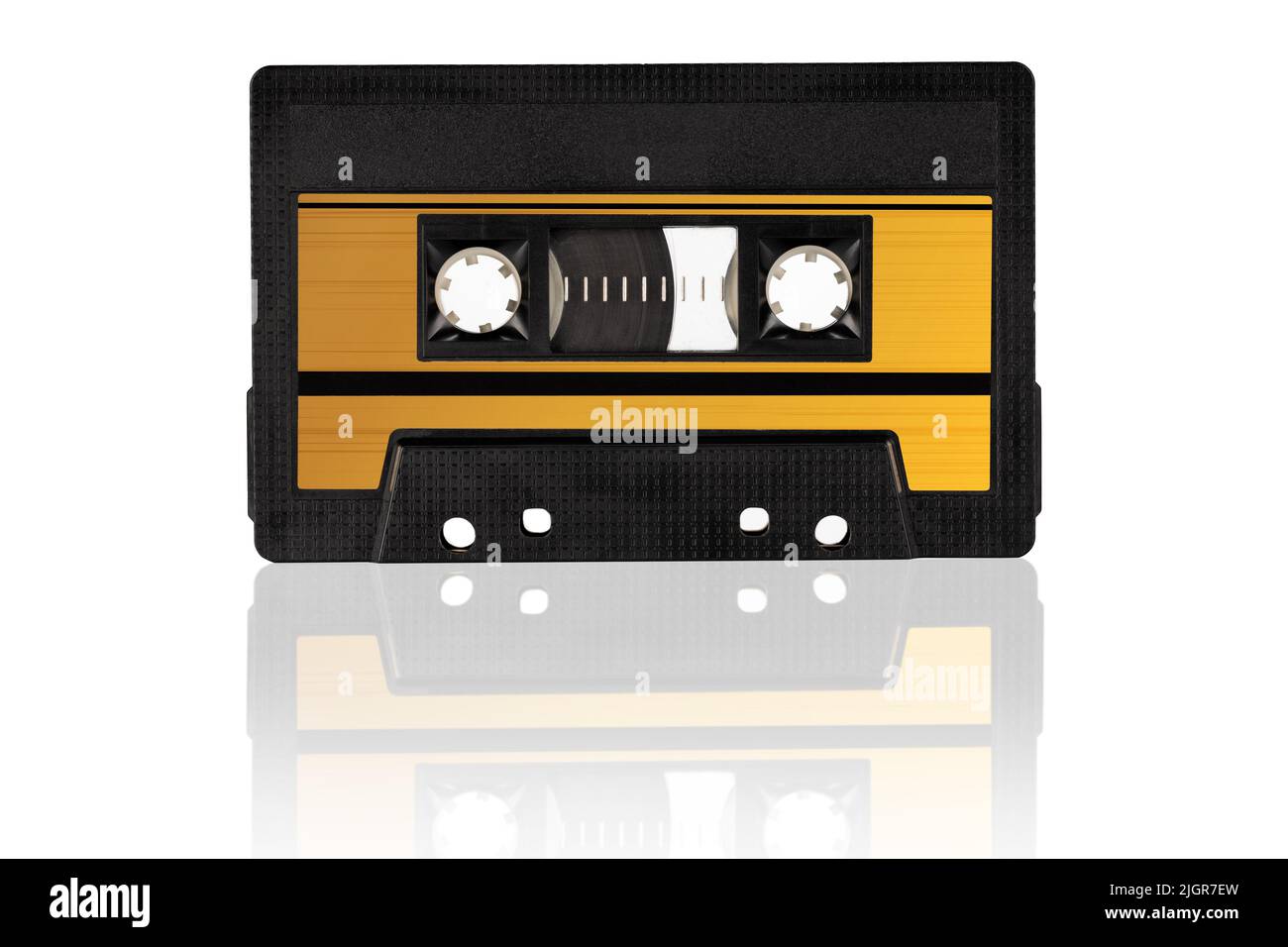 Retro gold audio cassette isolated on white background, close-up. Eye level shot. Stock Photo