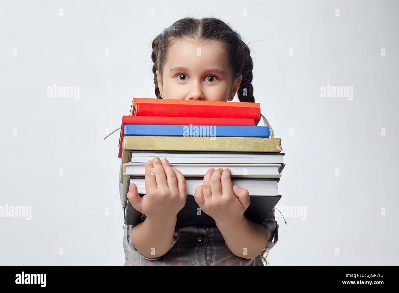 little girl holds a large stack of books in front of her. photo shoot ...
