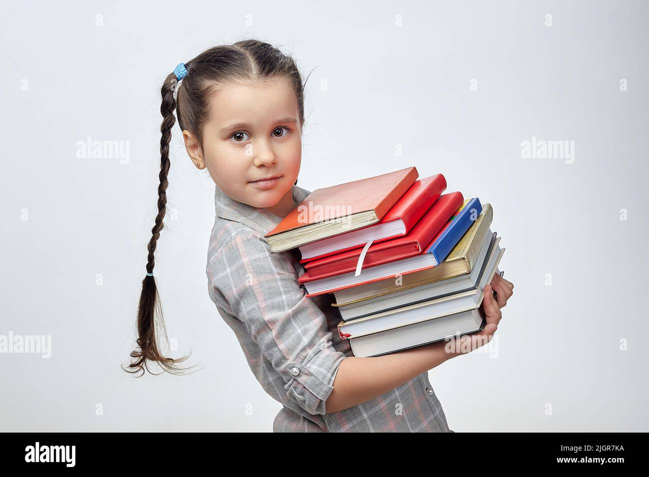 little girl holds a large stack of books in front of her. photo shoot ...