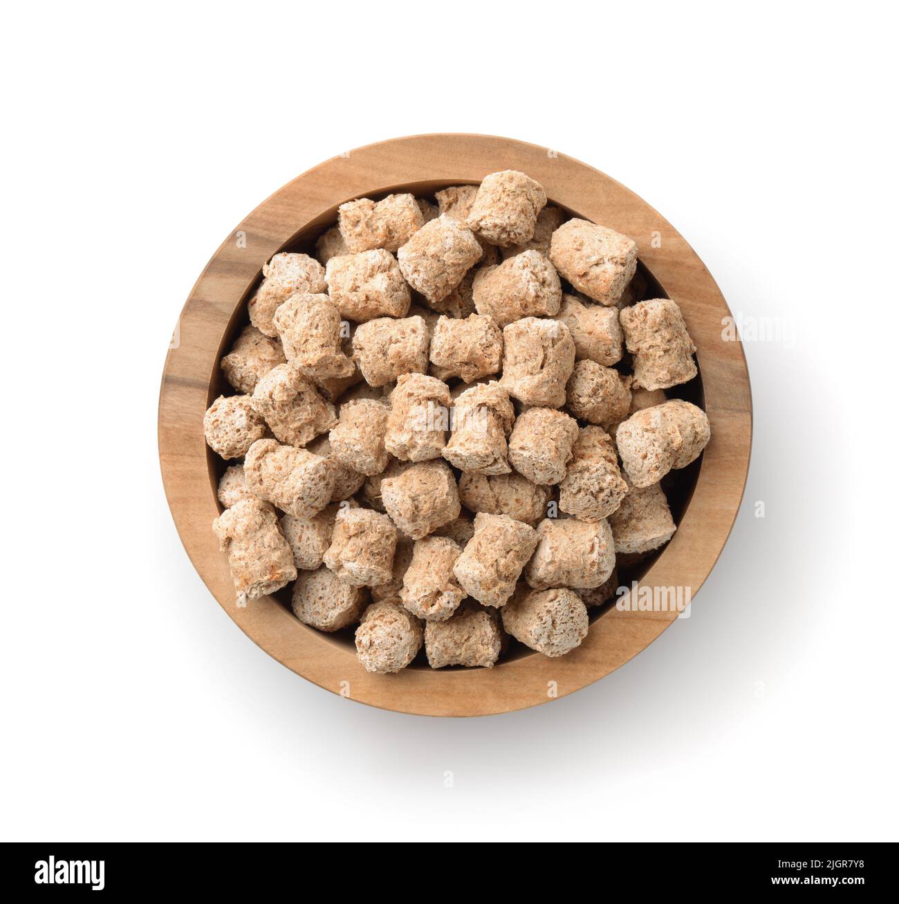 Top view of oats bran pellets in wooden bowl isolated on white Stock Photo