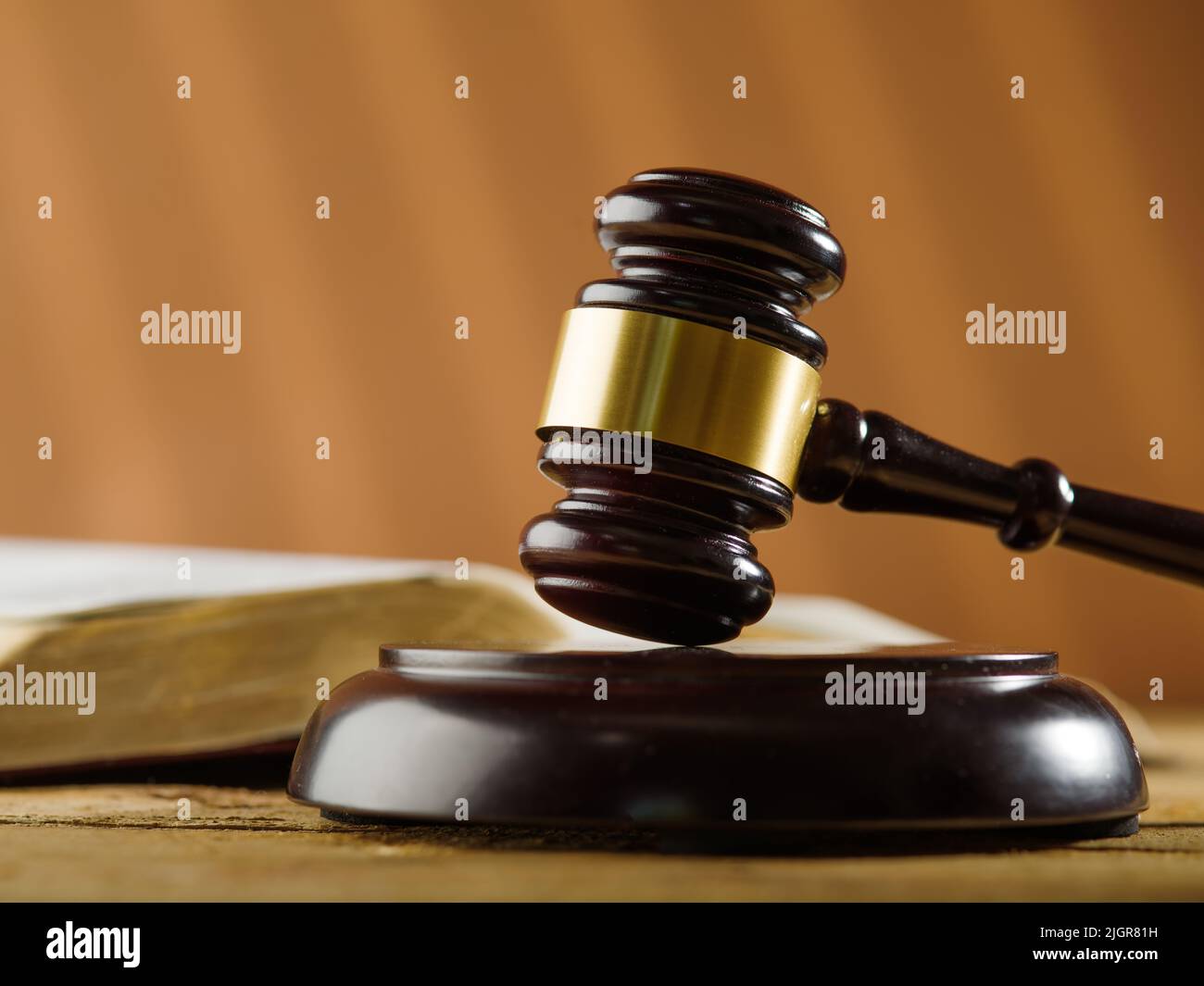 The symbols of a fair trial are a judge's gavel and an open book on a wooden table on a beige background. Close-up. Court and justice, Constitution, v Stock Photo