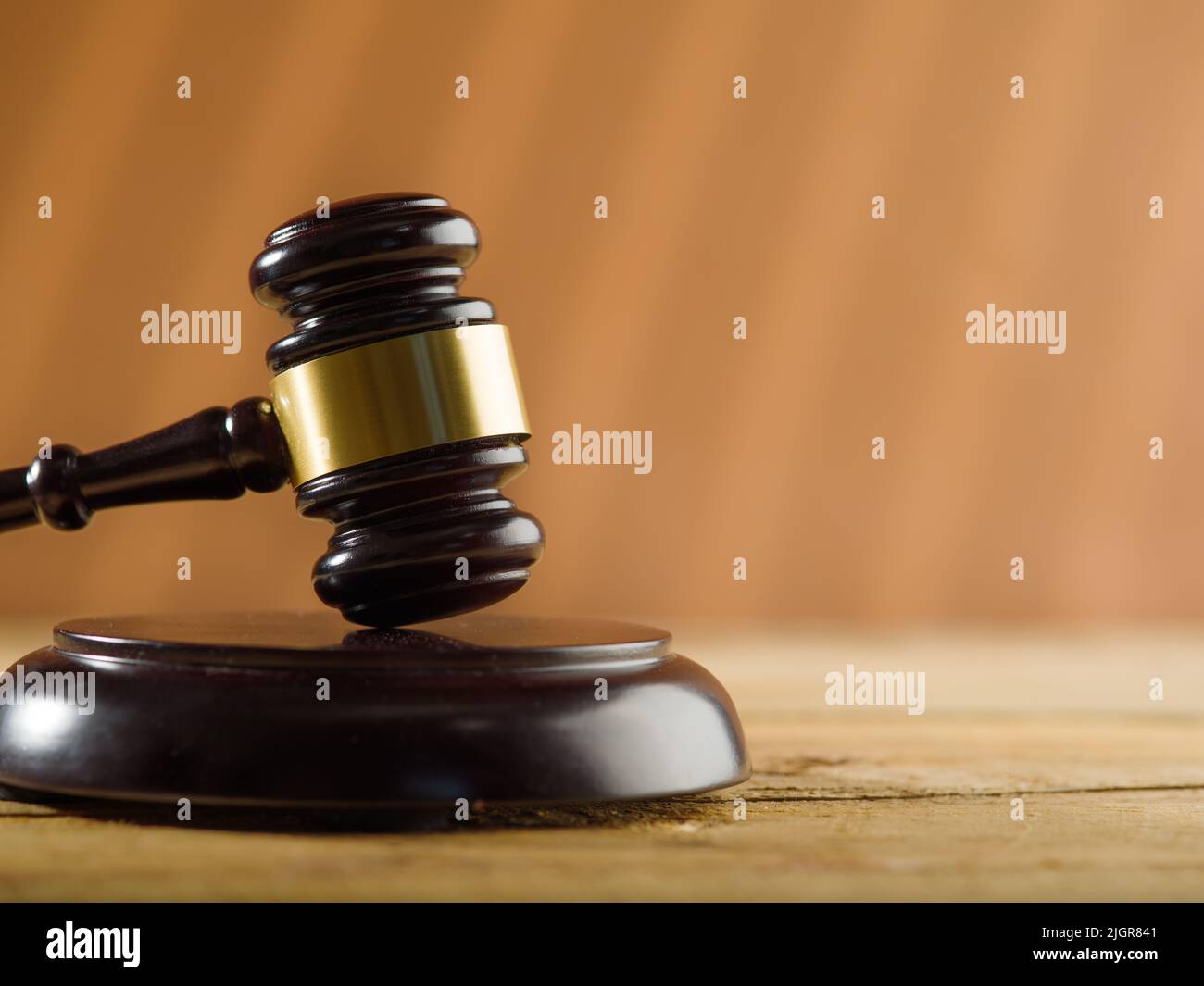 On a dark beige background, a wooden gavel of a judge. The concept is judgment and justice. Crime, punishment, rule of law, judge, lawyer. There is fr Stock Photo