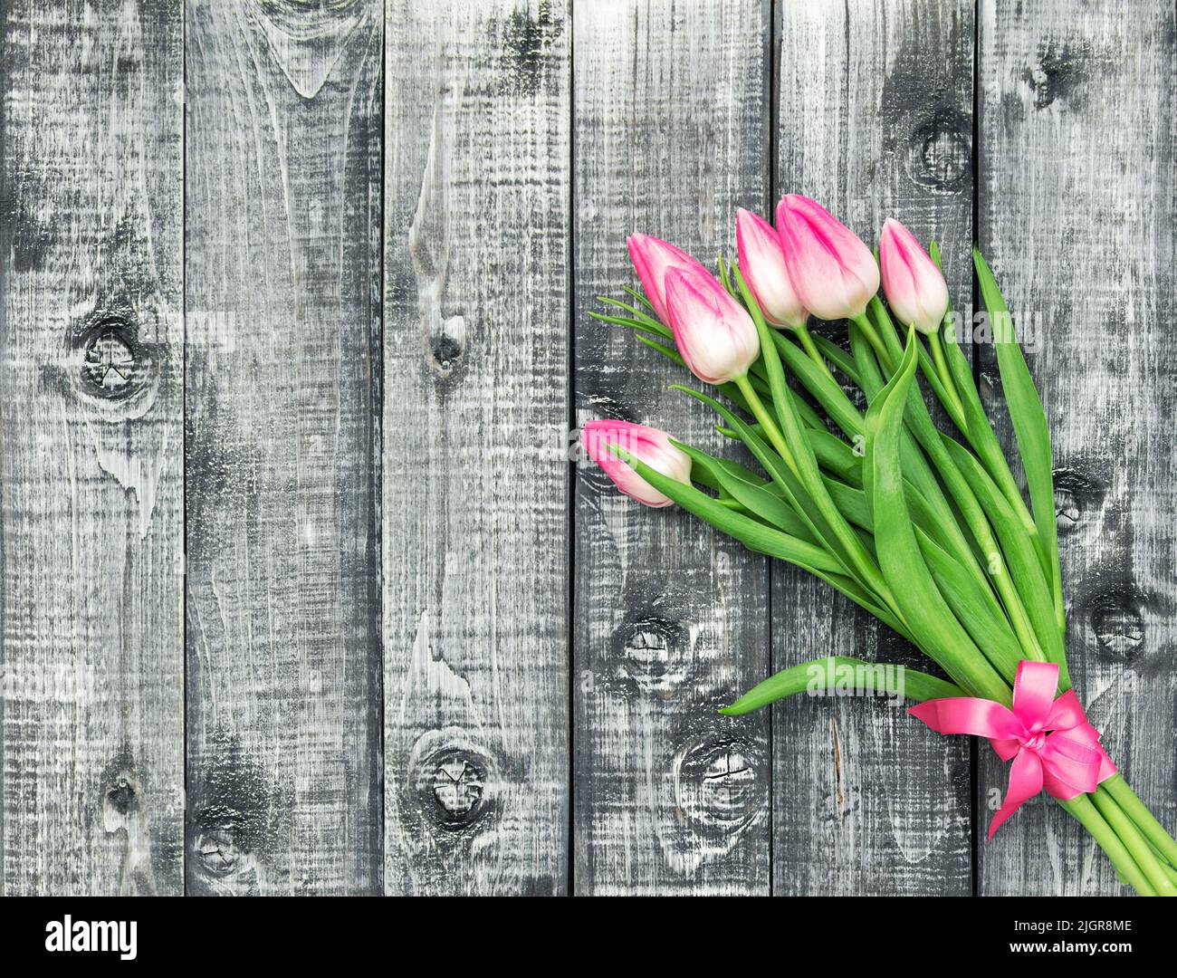 Pink tulip flowers. Spring bouquet decoration on rustic wooden background Stock Photo