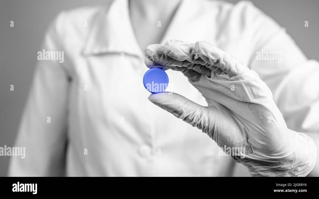 Doctors prescription concept. Hand holding round circle blue pill