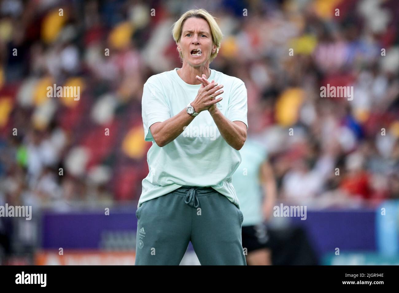 12 July 2022, Great Britain, Brentford/ London: Soccer, Women: European Championship, Germany - Spain, preliminary round, Group B, Matchday 2, Brentford Community Stadium. German coach Martina Voss-Tecklenburg cheers on the players during the warm-up. Photo: Sebastian Christoph Gollnow/dpa Stock Photo