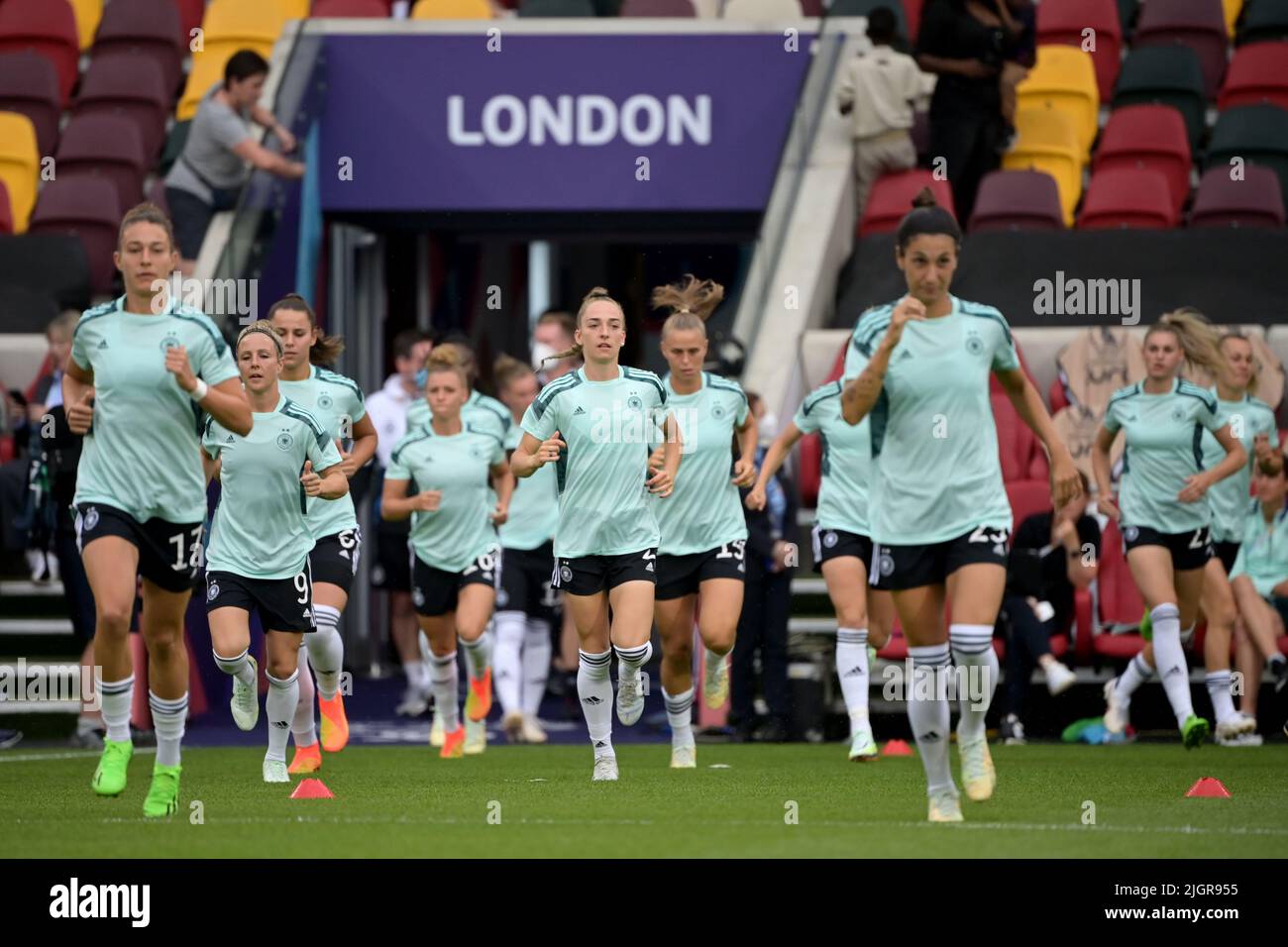 12 July 2022, Great Britain, Brentford/ London: Soccer, Women: European Championship, Germany - Spain, Preliminary Round, Group B, Matchday 2, Brentford Community Stadium. Germany's players run onto the pitch for warm-up. Photo: Sebastian Christoph Gollnow/dpa Stock Photo