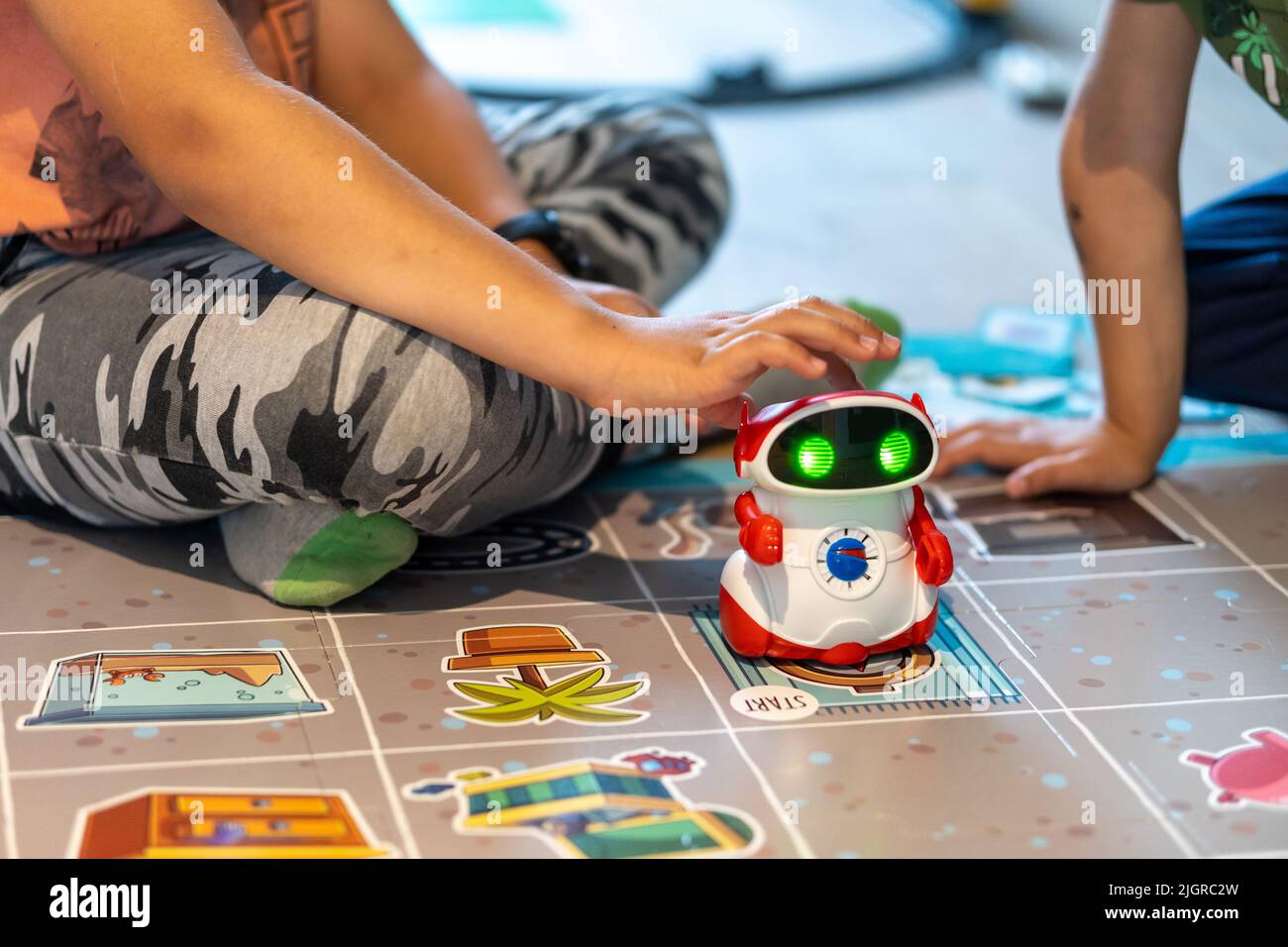 Two children playing with a Super Doc educational robot by Clementoni brand  on a mat Stock Photo - Alamy