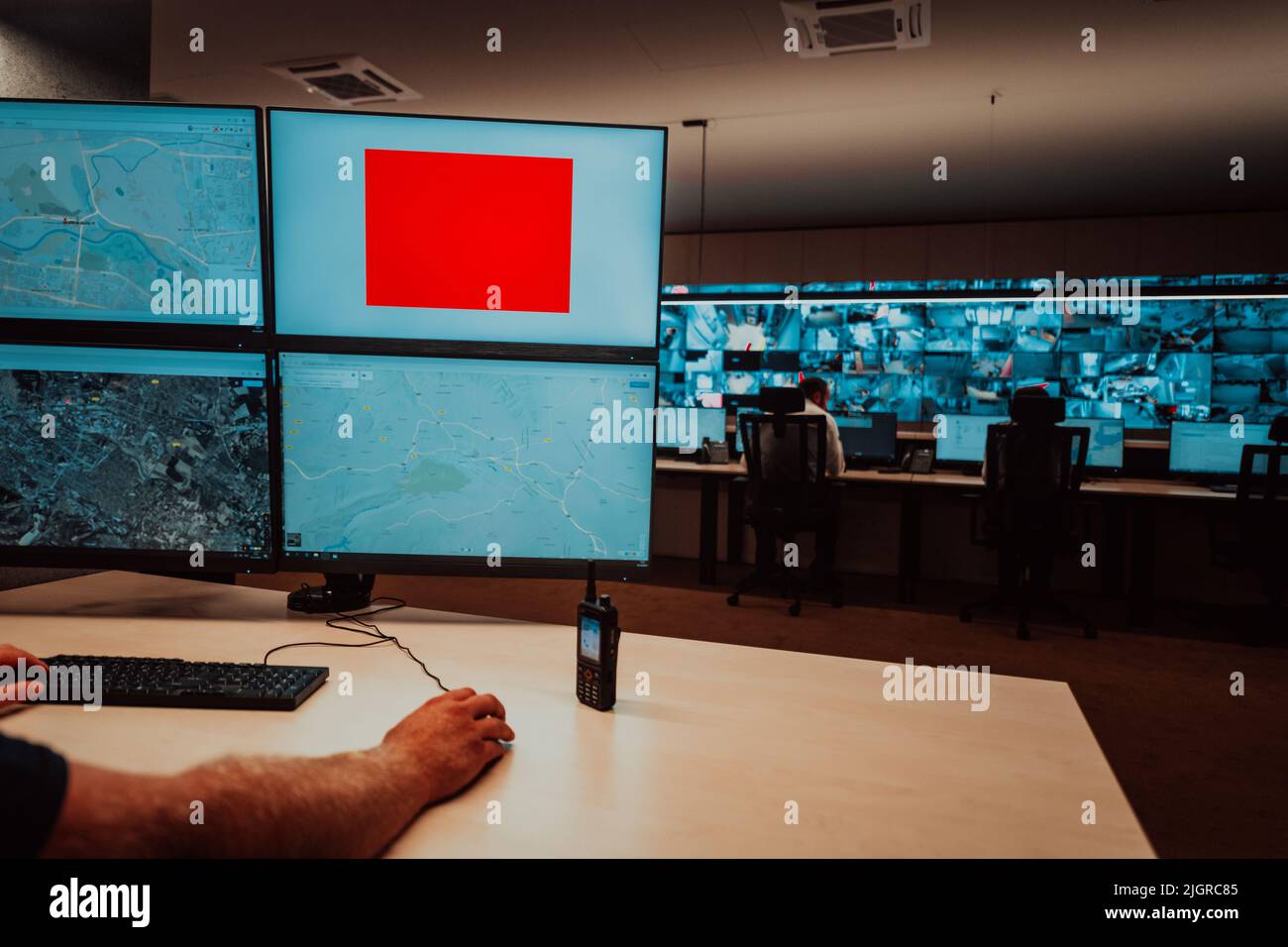 Male security operator working in a data system control room offices ...