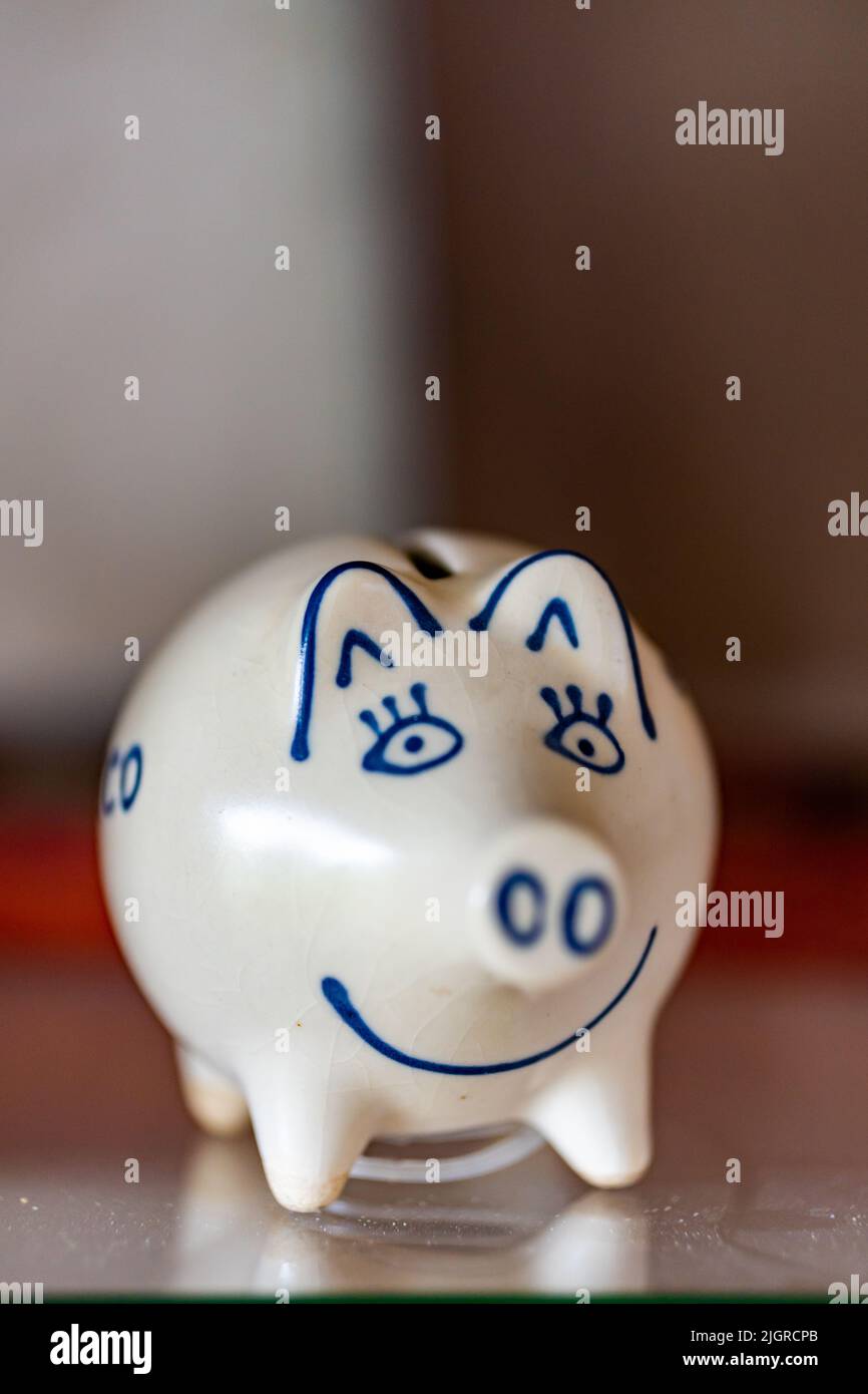 A vertical shot of a white coin box in the form of a smiling pig Stock ...