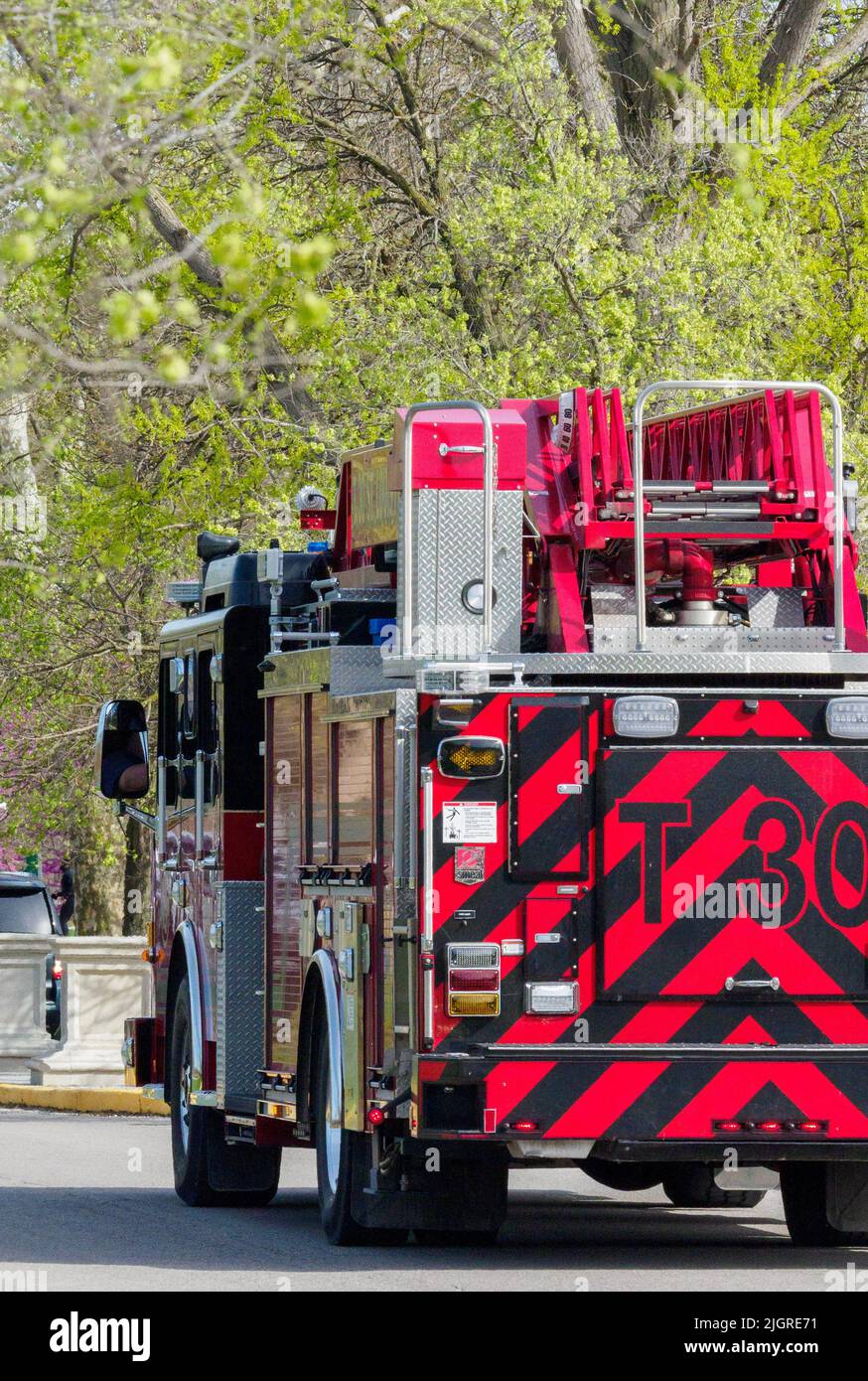 A vertical shot of a fire engine moving down the street in Saint Louis, United States Stock Photo