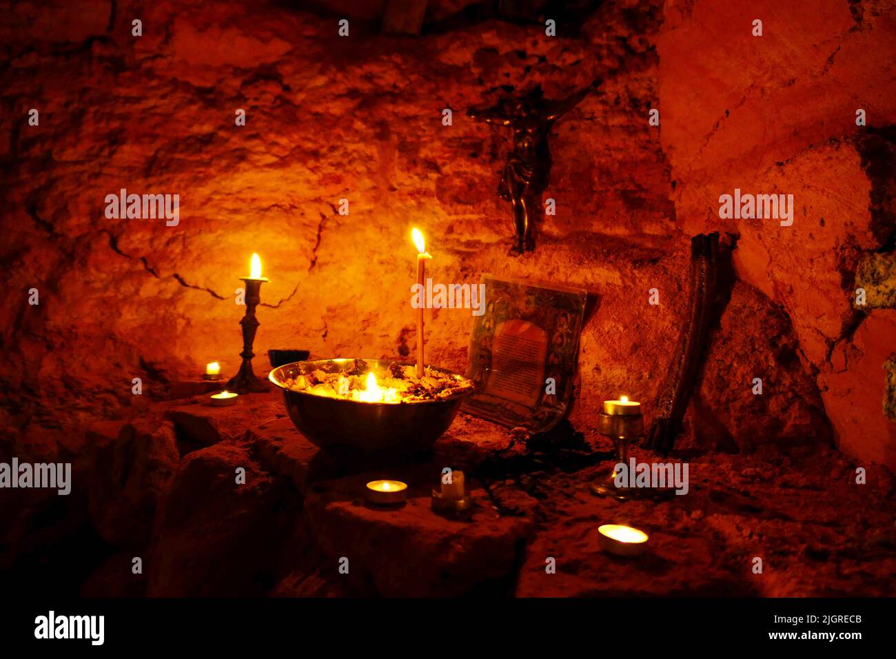 ODESA, UKRAINE JULY 10, 2022 Candles burn before a crucifix at an underground chapel in