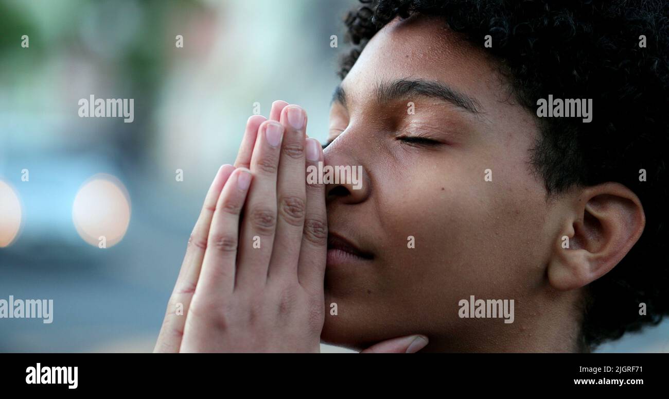 Child closing eyes praying. Spiritual kid prays with eyes closed Stock
