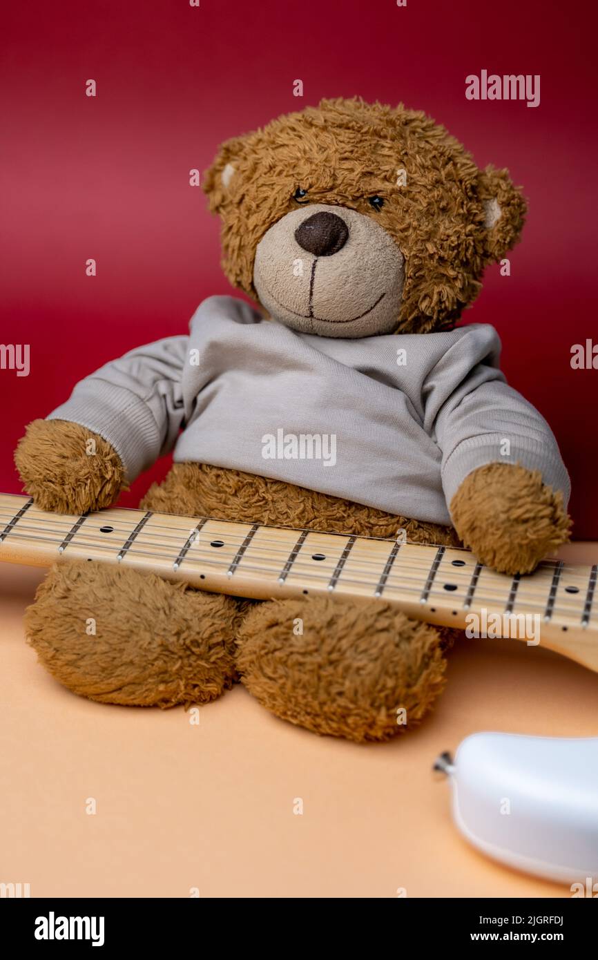 A Teddy Bear playing the Guitar. Cute Teddy bear with Guitar. Plush guitar. Stock Photo