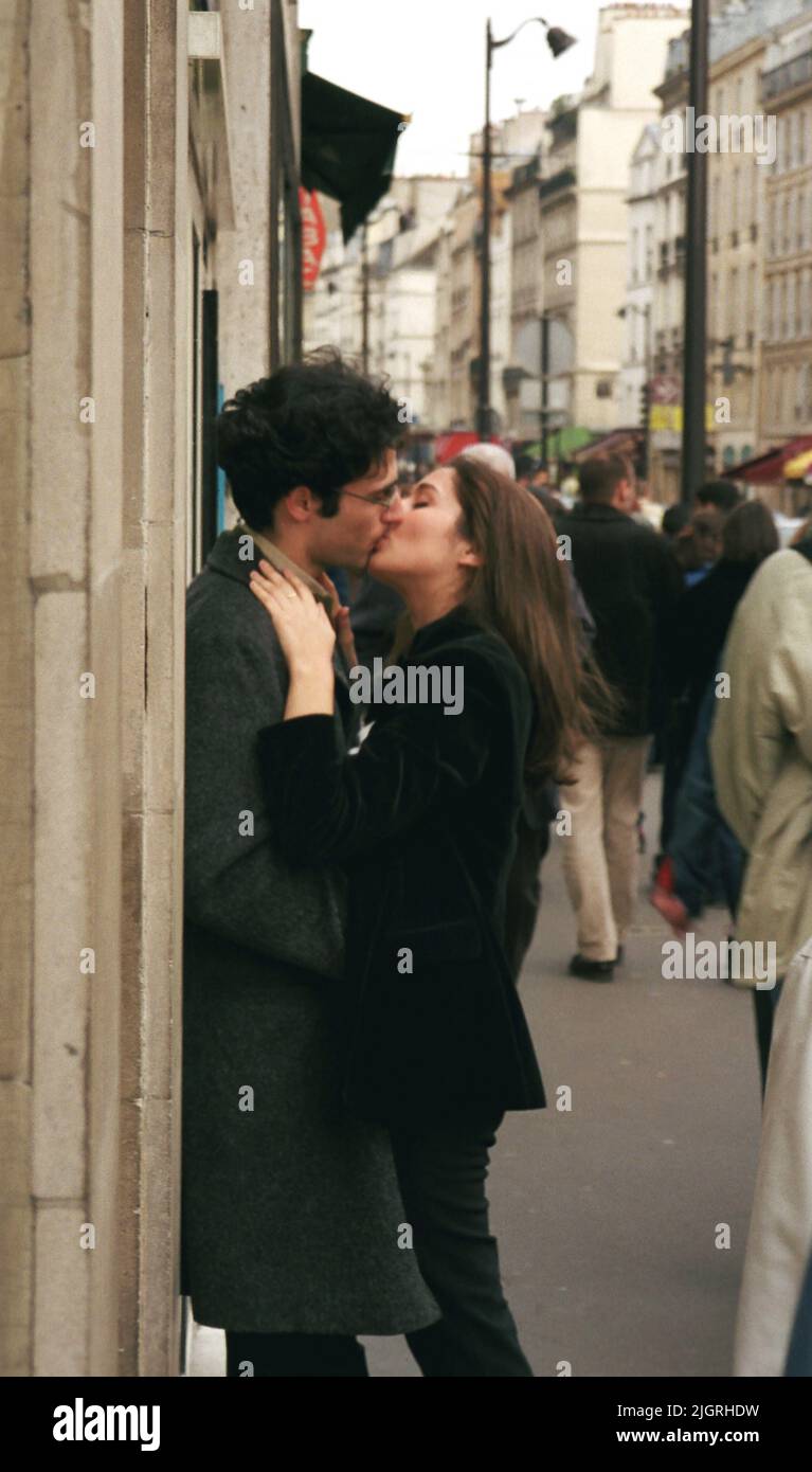 Oblivious of passersby, a young couple kiss on a public street in