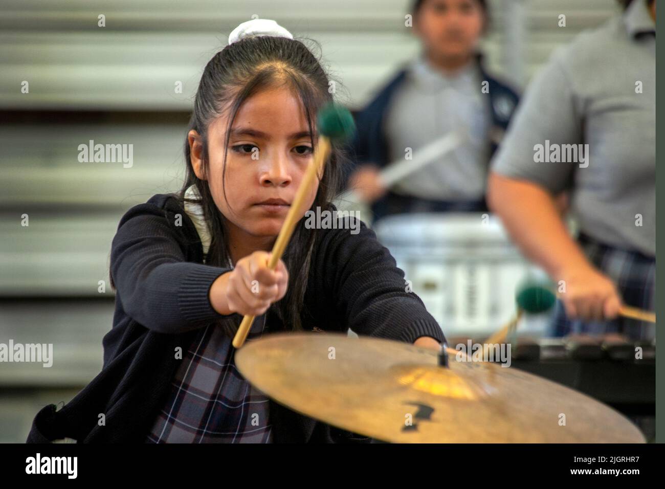 A student plays the cymbal in the orchestra of a Santa Ana, CA, parochial school. Stock Photo