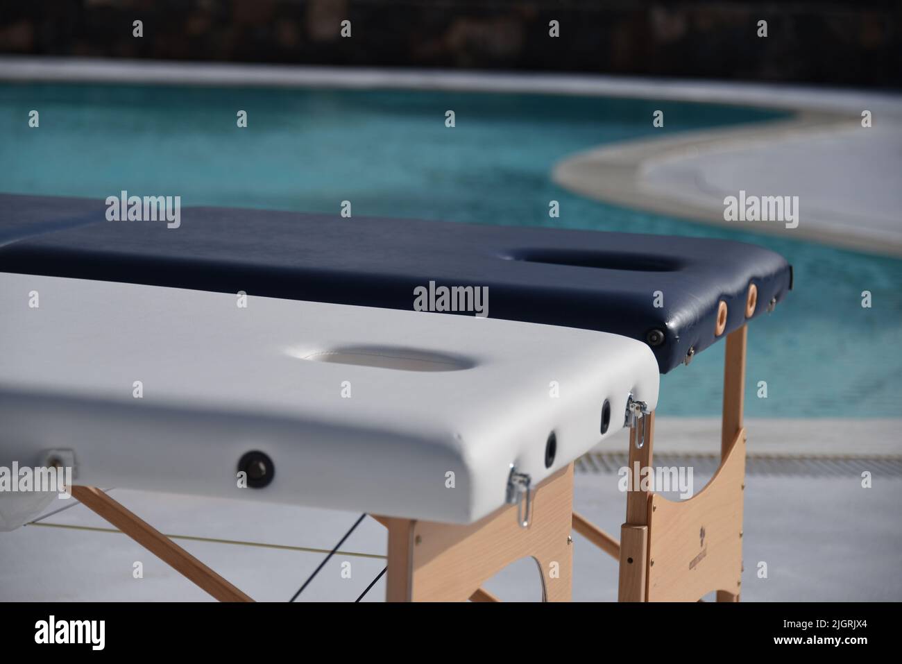 A scenic view of massage tables poolside in sunny weather in a blurred background Stock Photo