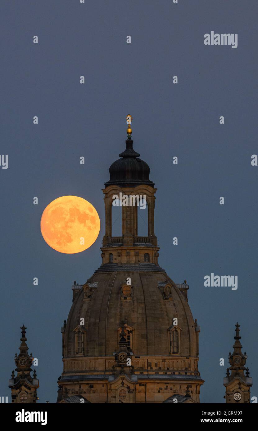 Dresden, Germany. 12th July, 2022. The waxing moon rises in the evening behind the Frauenkirche. On July 13, 2022, the moon will be full shortly after 8:30 pm. At the same time, the moon is close to the earth, which is why it is called a supermoon. Credit: Robert Michael/dpa/Alamy Live News Stock Photo