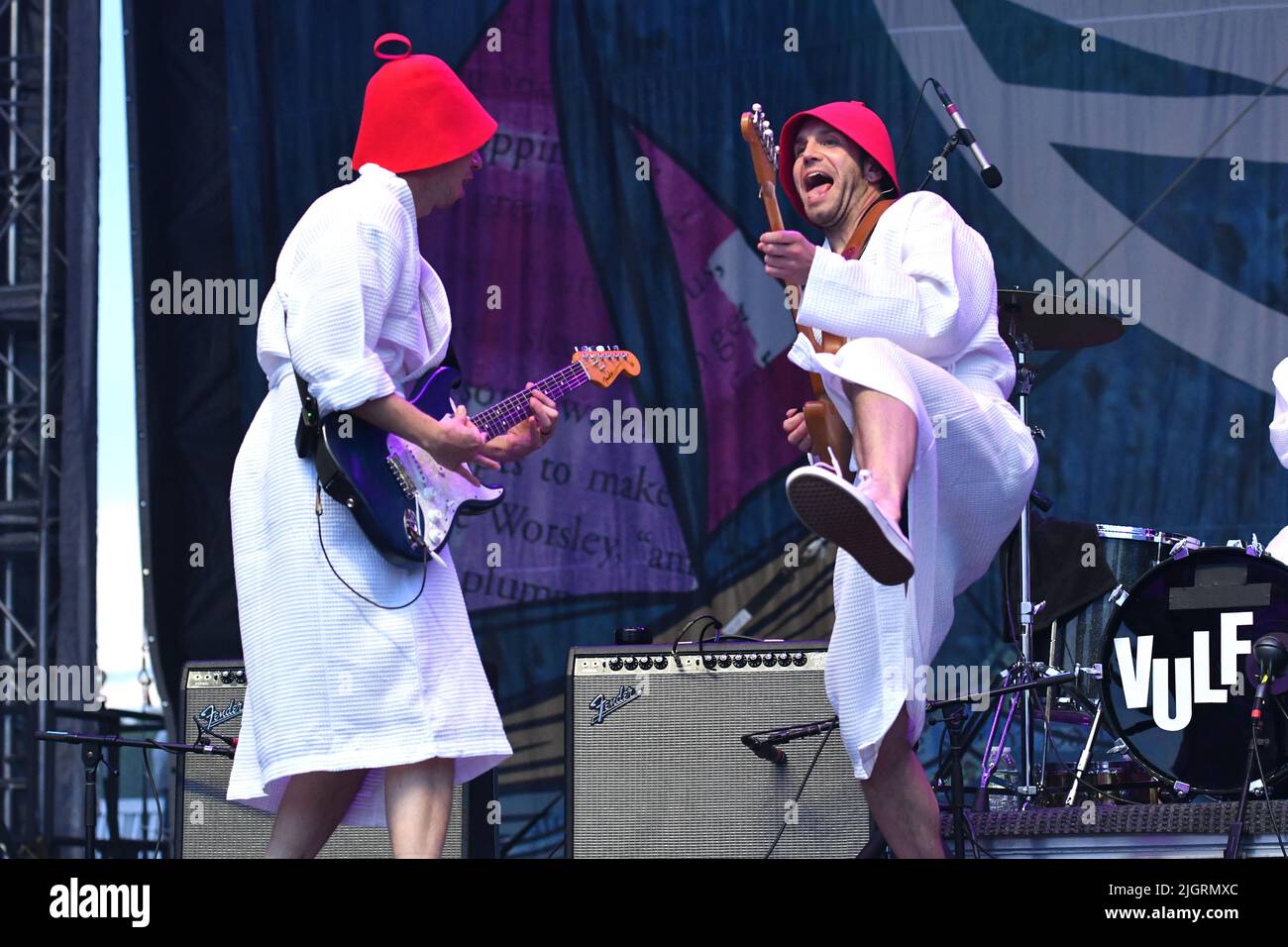 Vulfpeck band members are shown performing on stage during a “live